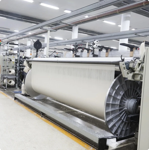 A power loom at Donear, one of our fabric mills, weaving fabric onto the cloth beam
