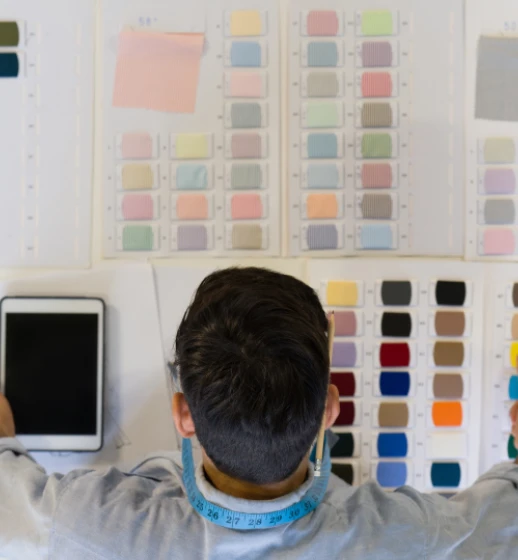 A colourist at Donear studying a wall of fabric shade cards