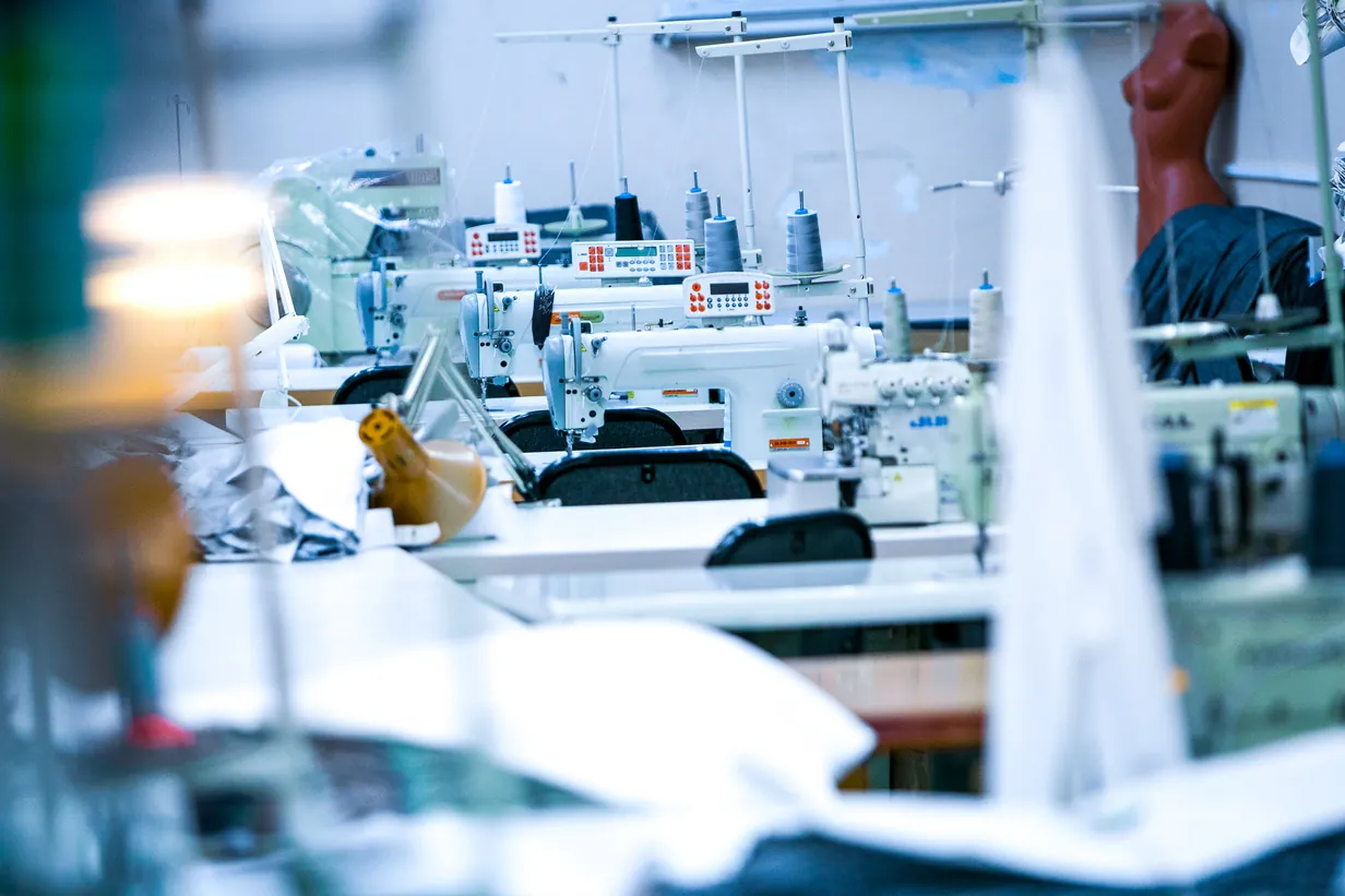Rows of industrial sewing machines on a stitching floor