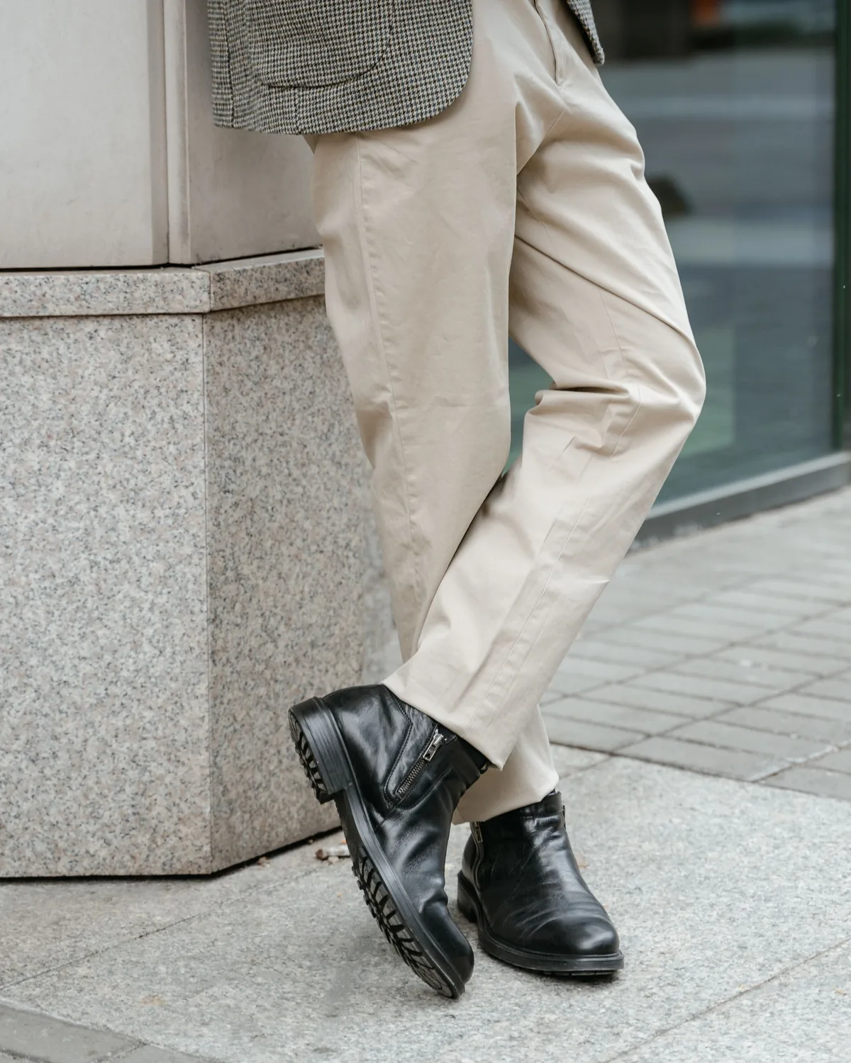 Cream cotton chino trousers with a straight leg, worn with black ankle boots and shown from the hip down while standing cross-legged